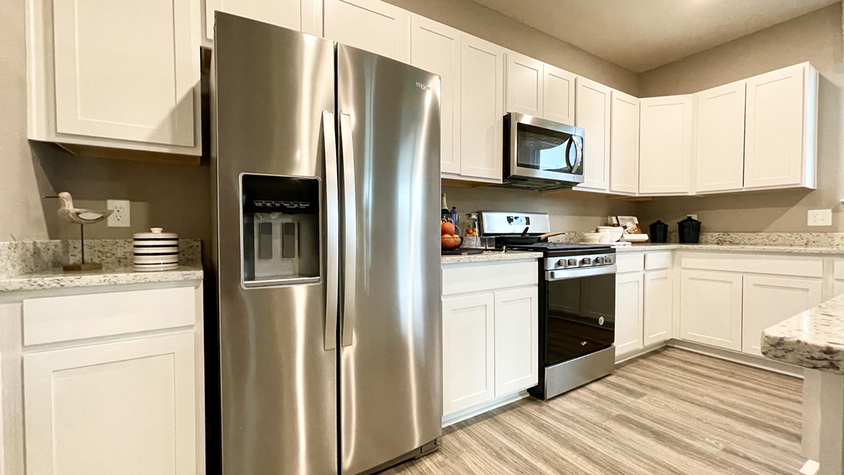 The spacious kitchen boasts an abundance of beautiful cabinetry.