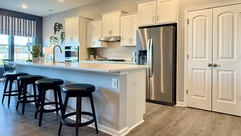 The open floorplan features a kitchen complete with upgraded cabinets.
