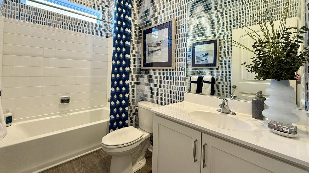 Just off the foyer, two spacious guest bedrooms and a shared full bathroom offer comfort and privacy for family or visitors.