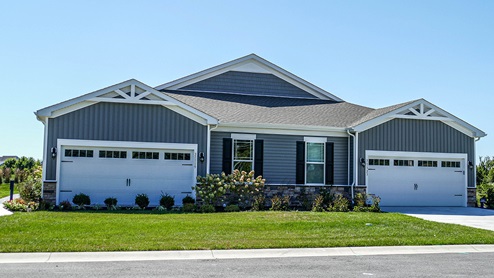 A front view of the Severn villa model with gray siding and a brick front.