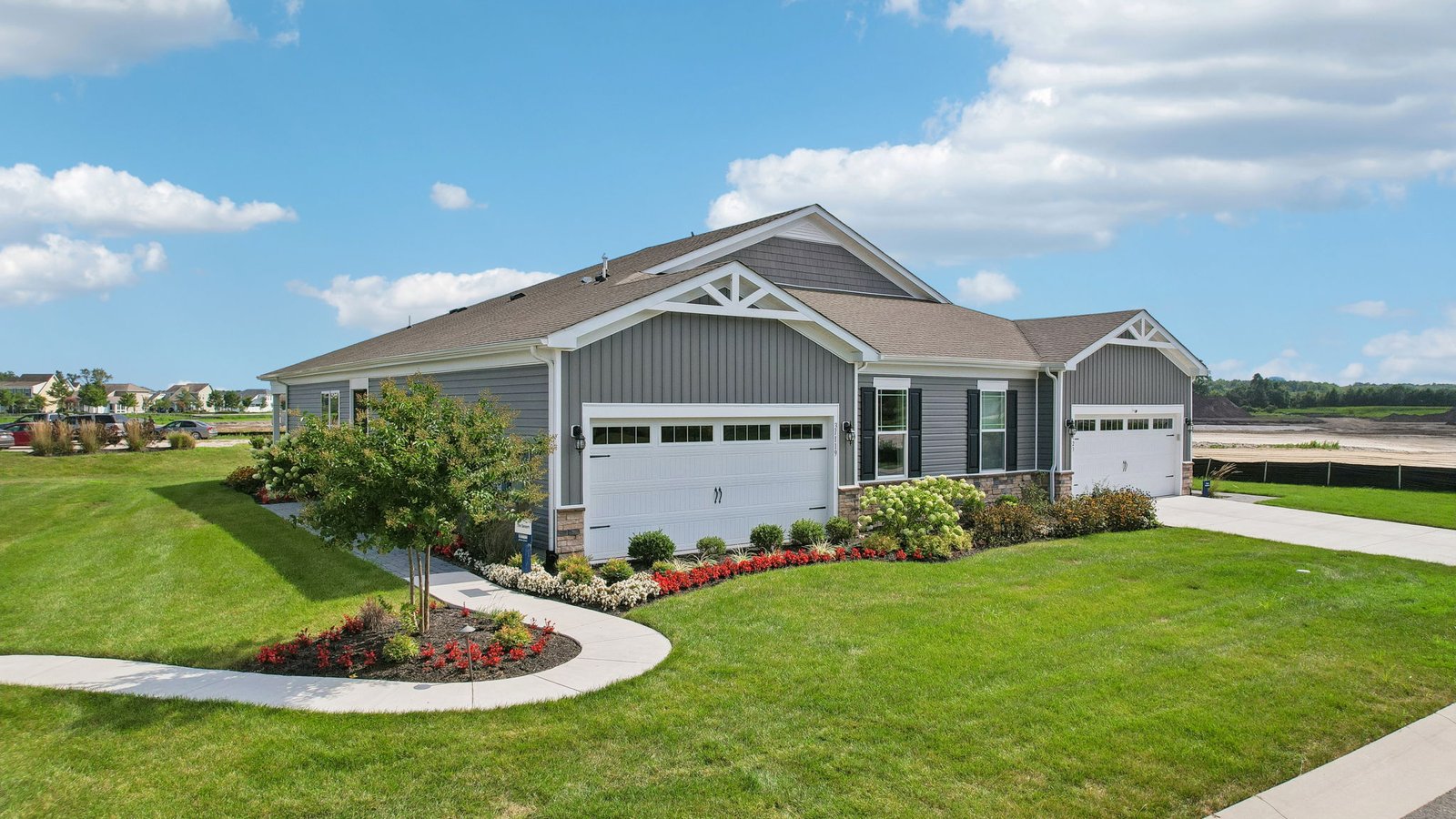 A front view of the Severn villa model with gray siding and a brick front.