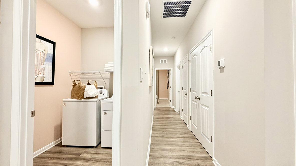 The laundry room is located near the guest bedrooms.