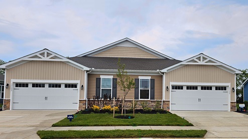 A front view of the Severn villa model with tan siding and a brick front.