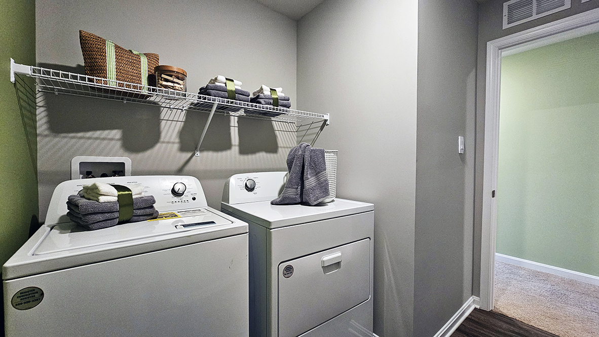Upstairs, there is a functional laundry room and a large hallway linen closet.
