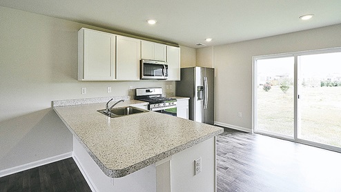 The kitchen has a peninsula island with granite countertops.