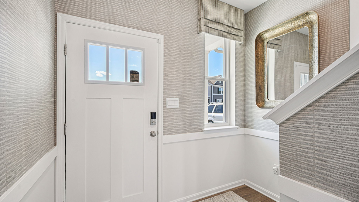 As you enter from the front porch, the inviting foyer leads you to a long hallway and stairwell.