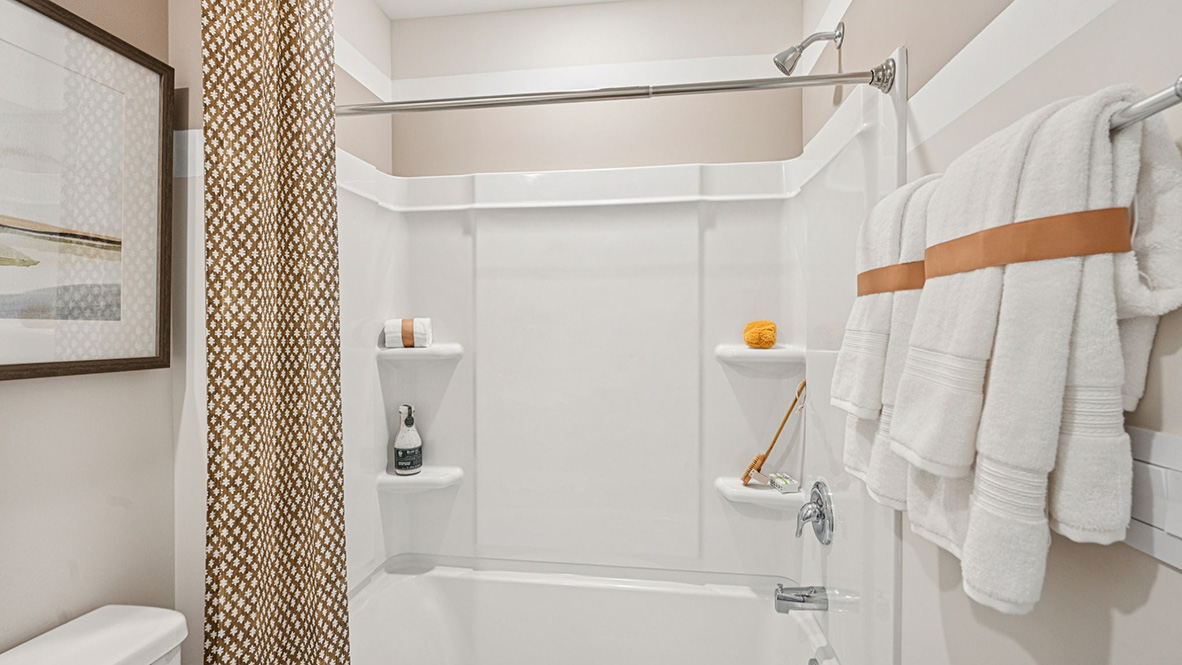 A guest bathroom with a vanity and tub shower is located down the hallway.