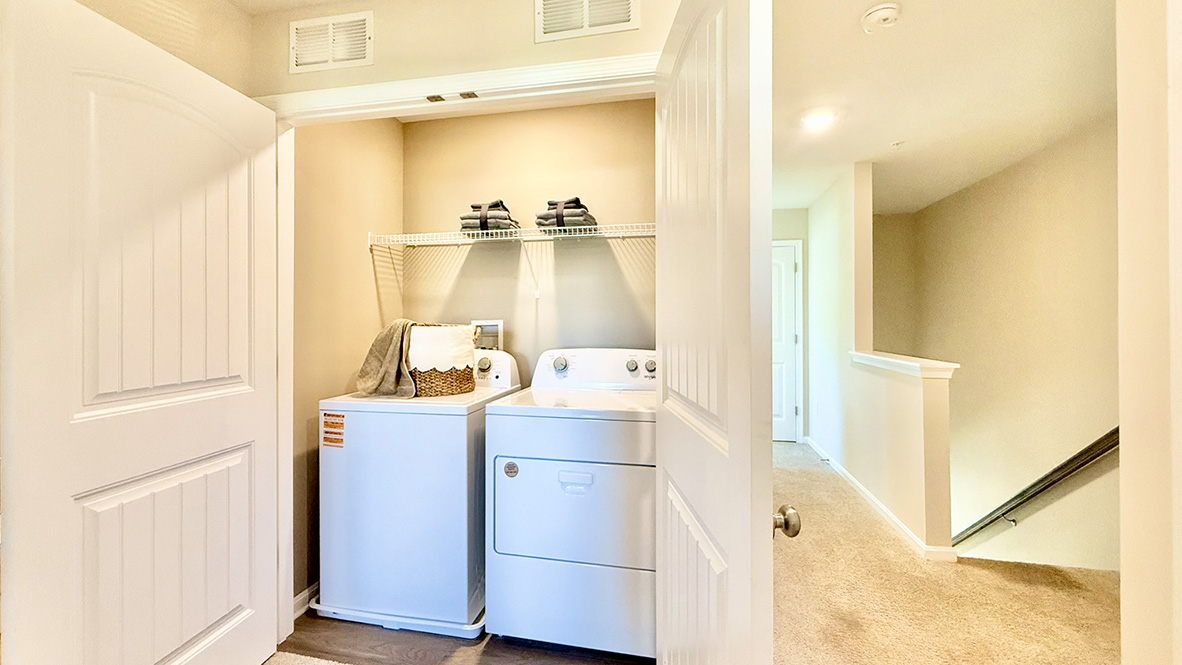 A functional upstairs laundry closet comes complete with a full-size washer and dryer.