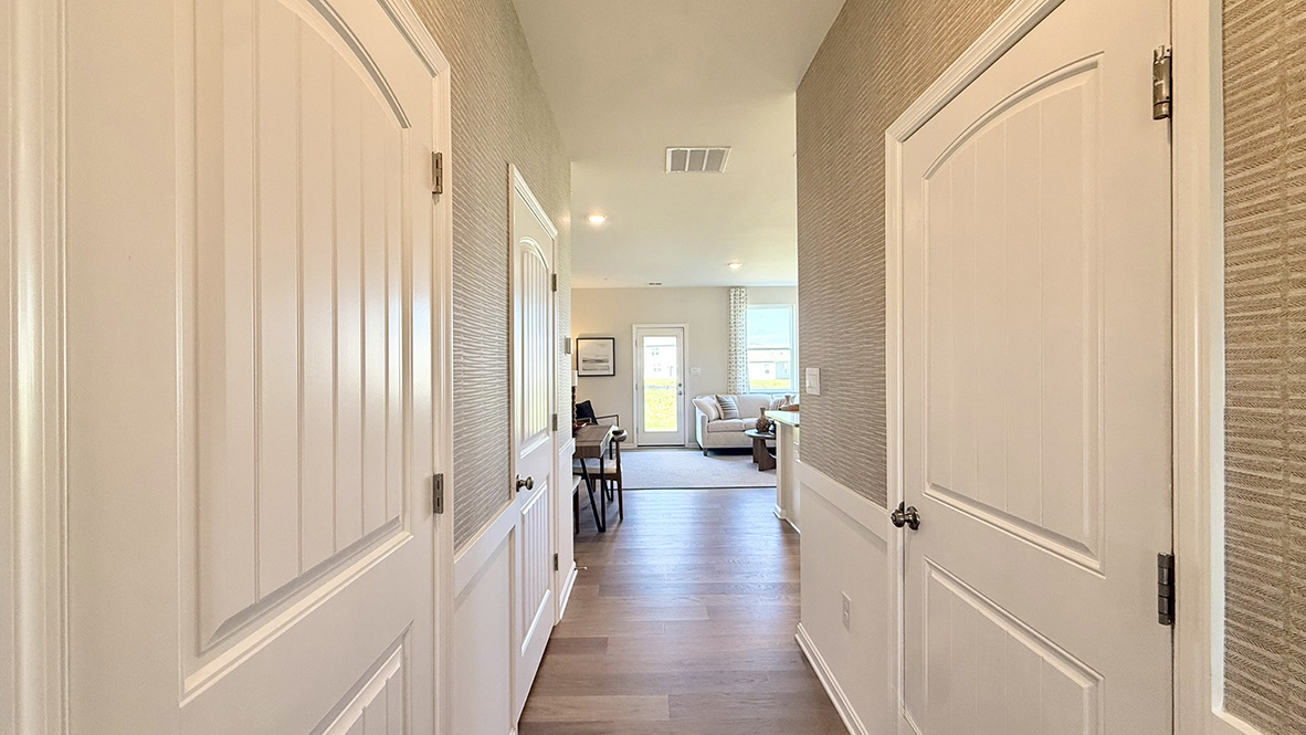 As you enter from the front porch, the inviting foyer leads you to a long hallway and the one-car garage.