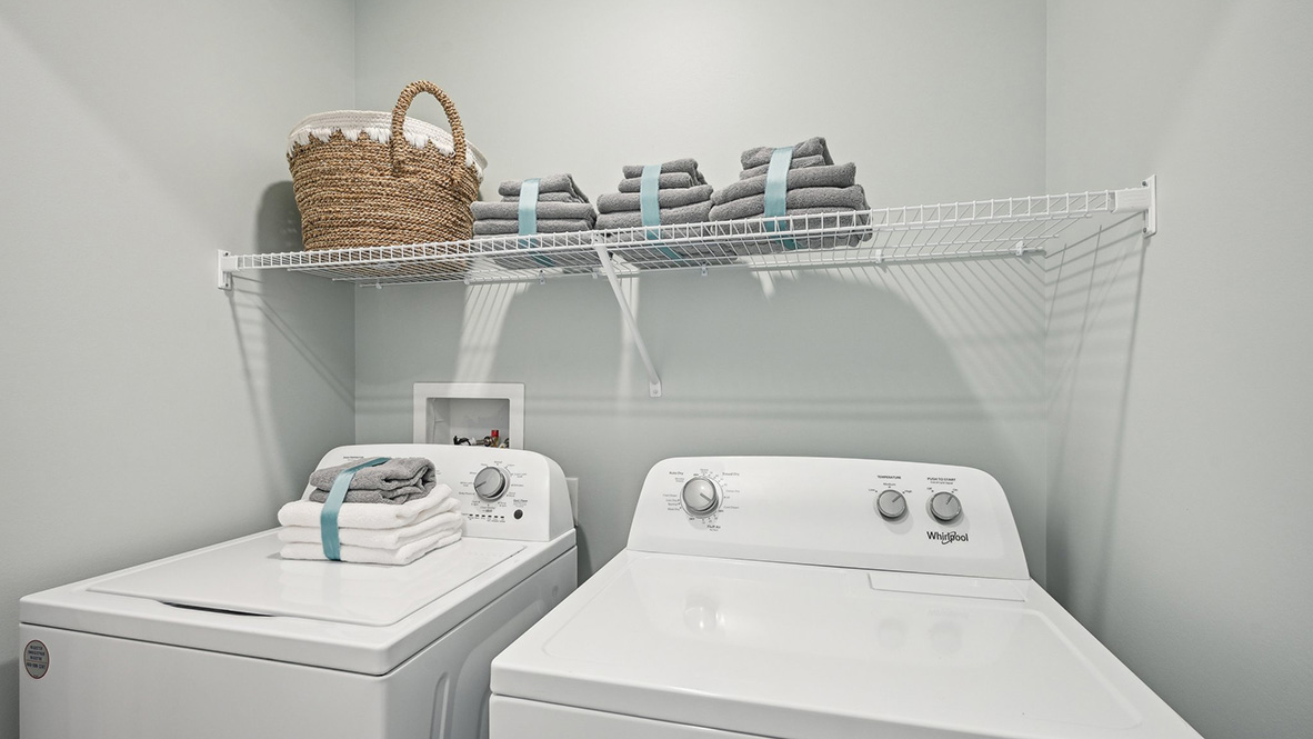 The laundry closet comes complete with a washer and dryer.
