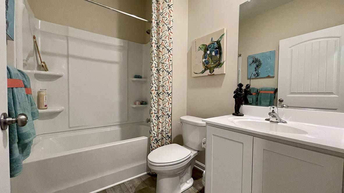 Modern bathroom with vanity, toilet, and shower.