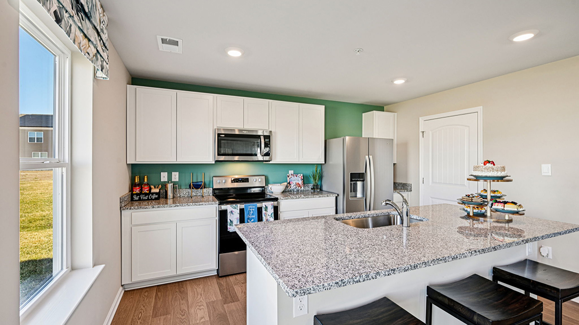 Open-concept kitchen with cabinets and a large island.