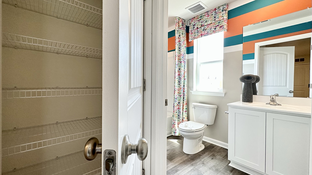 Continuing down the hallway, a hall bathroom and a linen closet are located upstairs.
