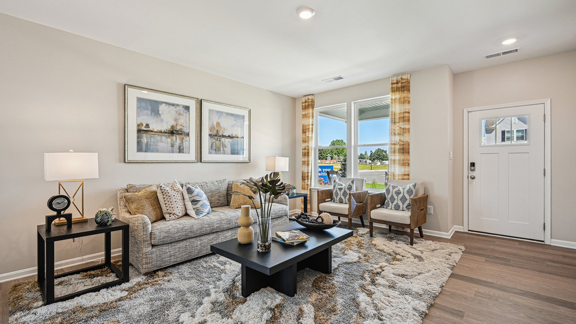 Upon entering through the inviting front porch, you’re welcomed into a bright and expansive great room.