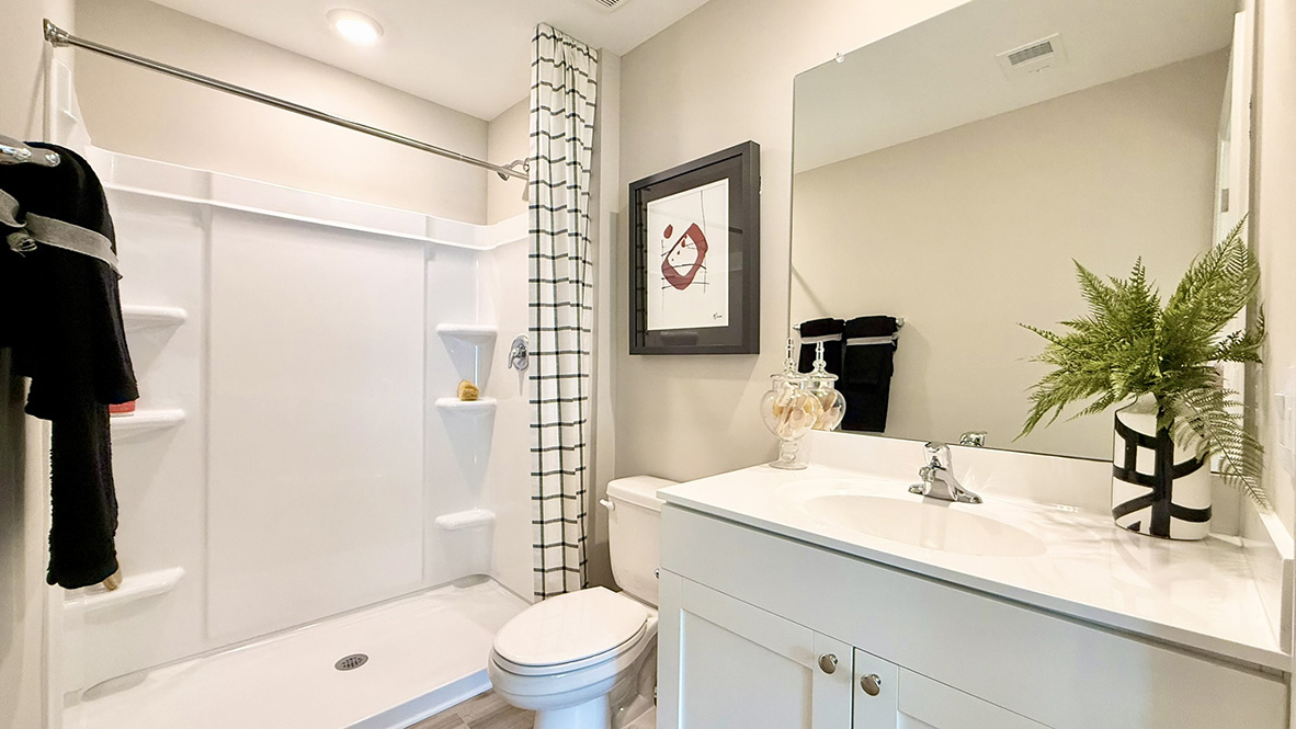 The large main bedroom has a private bath, single vanity, and walk-in shower.