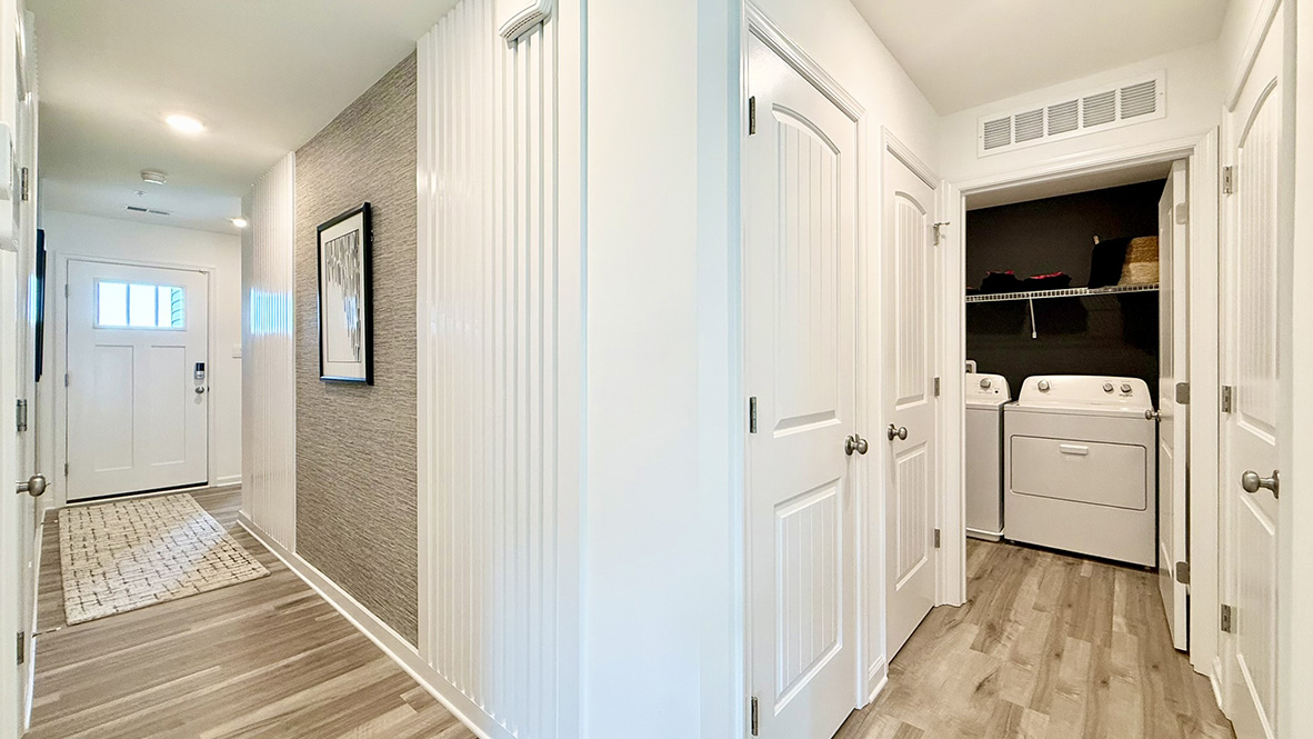 A tucked-away hallway leads to the pantry, a convenient coat closet, and the laundry room, keeping everyday essentials neatly organized.