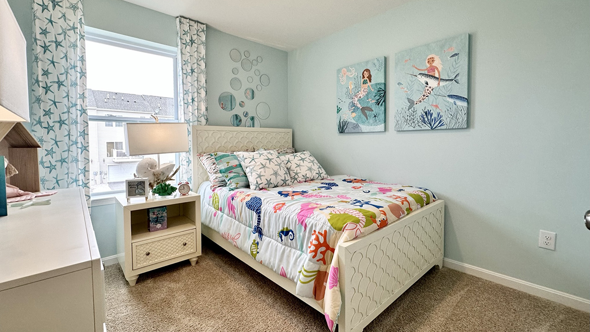 Secondary bedroom with carpet throughout and window.