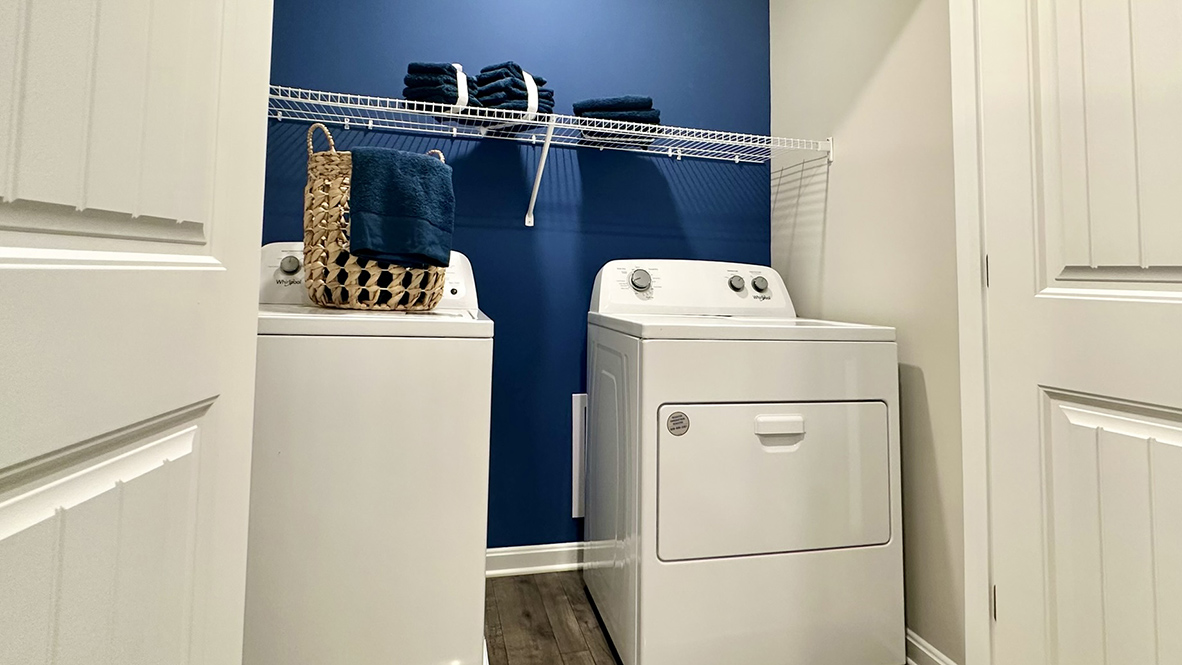 The cozy upstairs laundry closet is centrally located in the hallway.