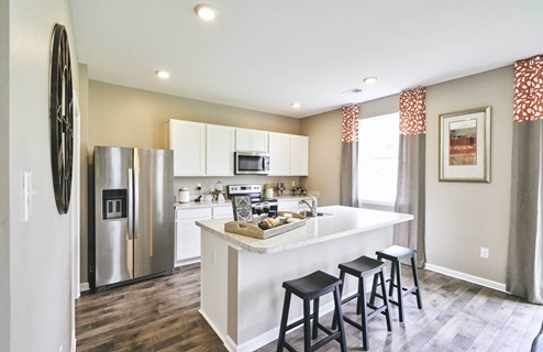 Galen kitchen with white cabinets and stainless steel appliances.