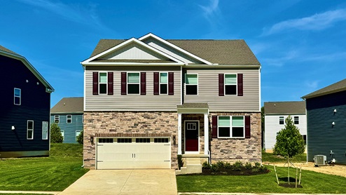 Hanover model home exterior with tan siding and maroon shutters.