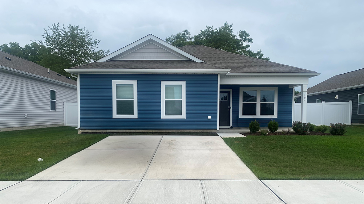 A one-story Curtis with blue siding.