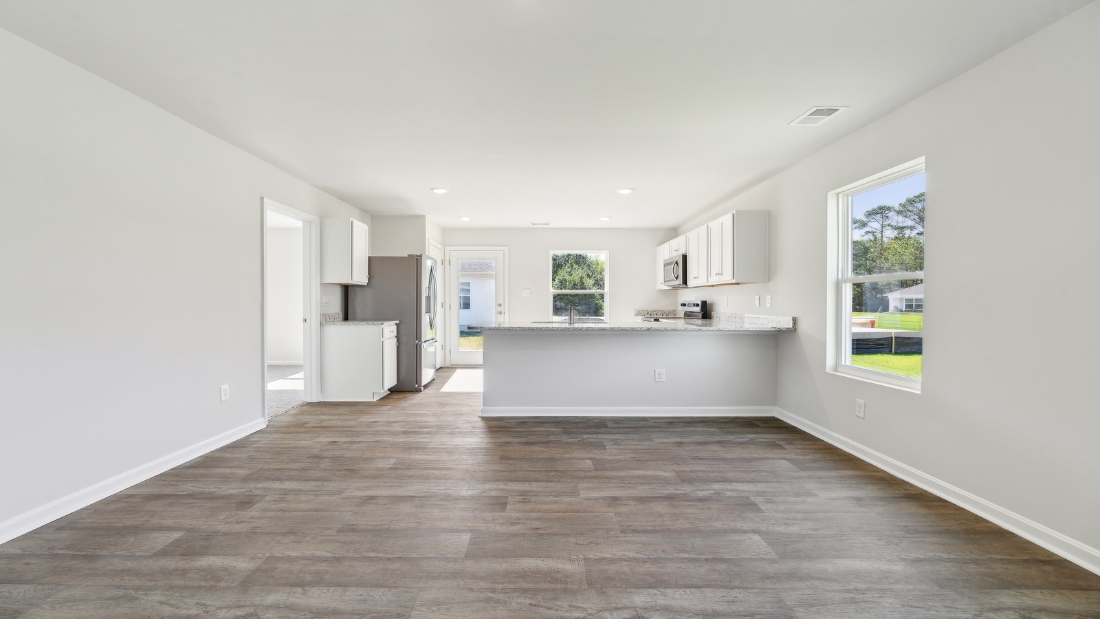 The spacious living room flows into the kitchen, creating a perfect space for entertaining guests or enjoying family time.