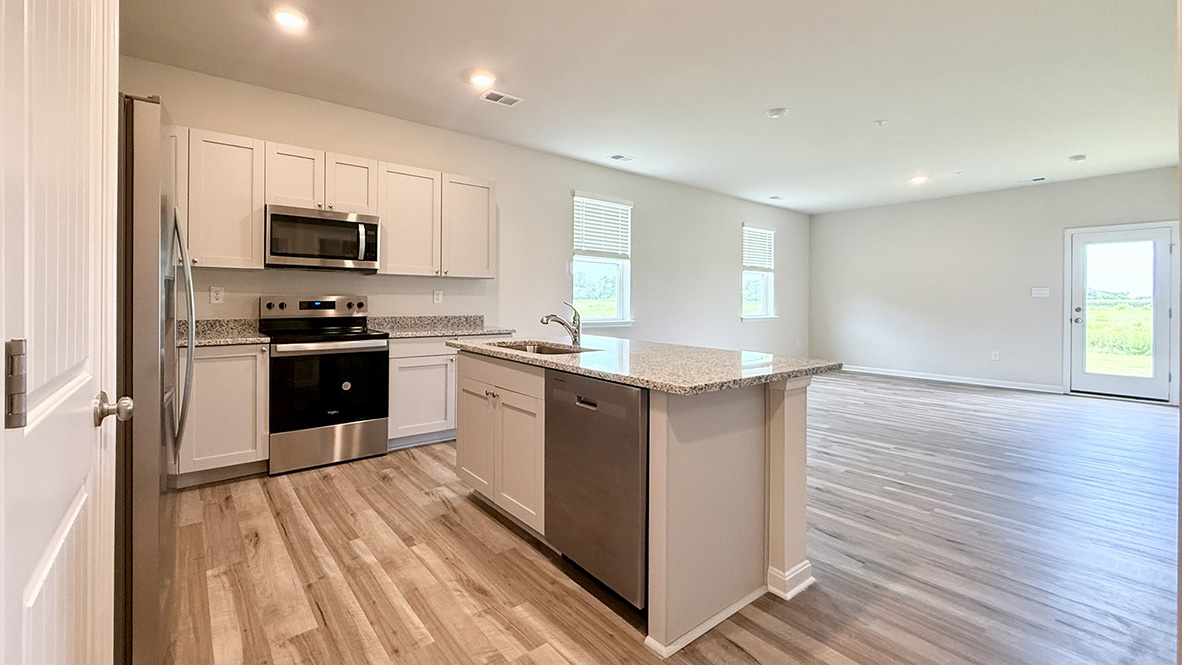 The well-appointed kitchen features an abundance of cabinetry, stainless steel appliances, a pantry and an island with additional room for seating.