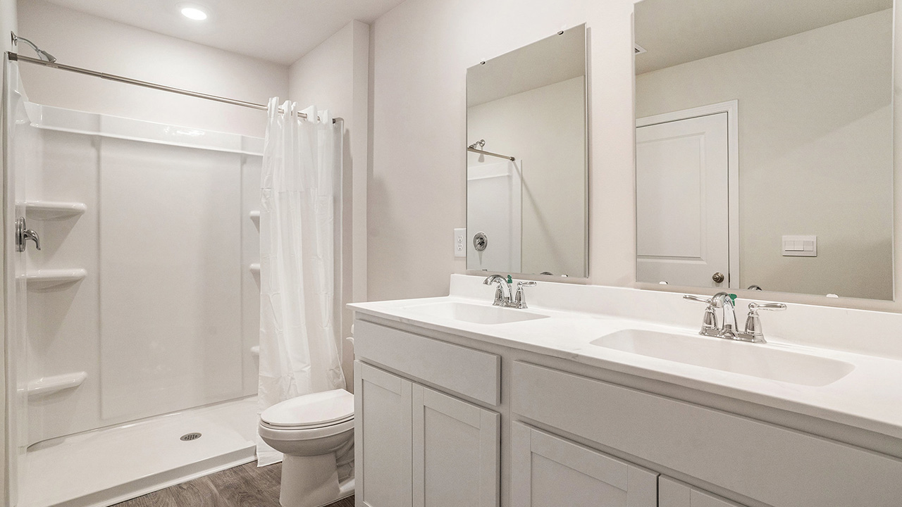 The full bathroom has a double-bowl vanity.