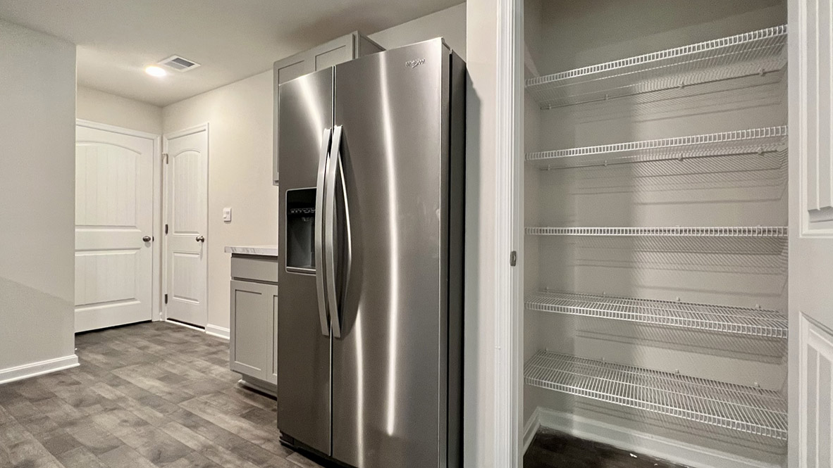 The kitchen offers an ample walk-in pantry.
