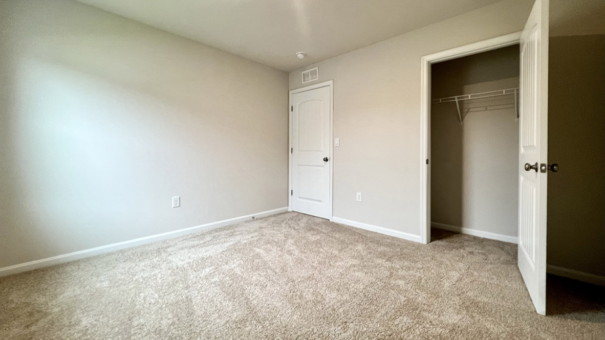 A secondary bedroom with a closet.