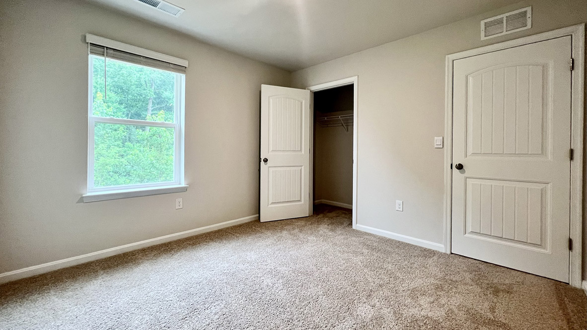 A secondary bedroom with a closet.