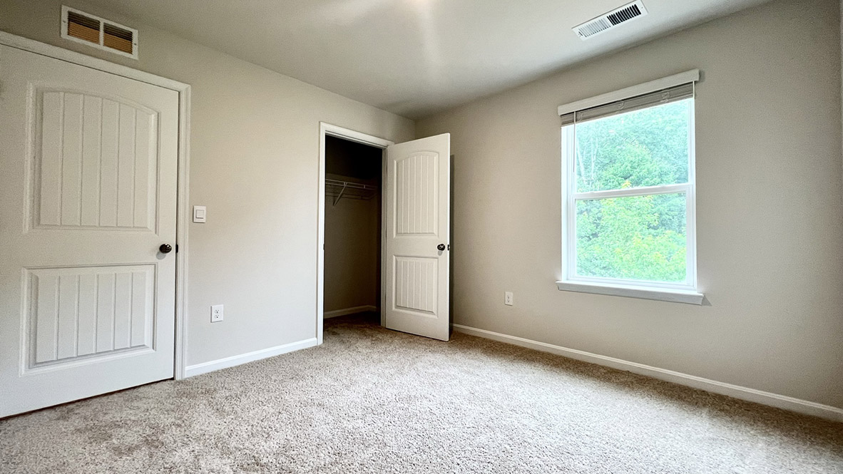 A secondary bedroom with a closet.