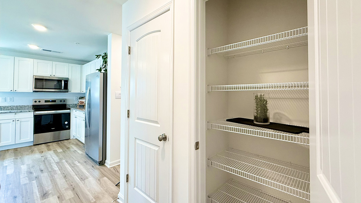 Across from the kitchen, a tucked-away hallway leads to the pantry.