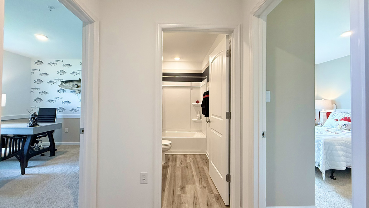 Just off the foyer, two spacious guest bedrooms and a shared full bathroom offer comfort and privacy for family or visitors.