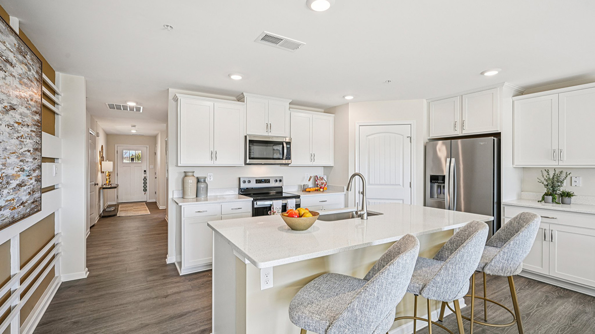 The open-concept kitchen has bright kitchen cabinets.