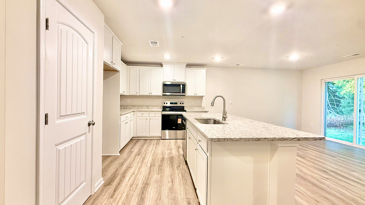 The functional kitchen offers plenty of granite countertops and a pantry closet.