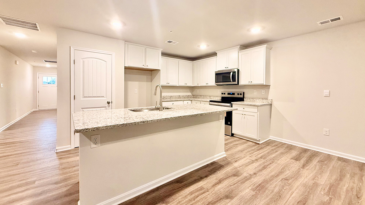 The functional kitchen offers a sizeable island with room for seating.