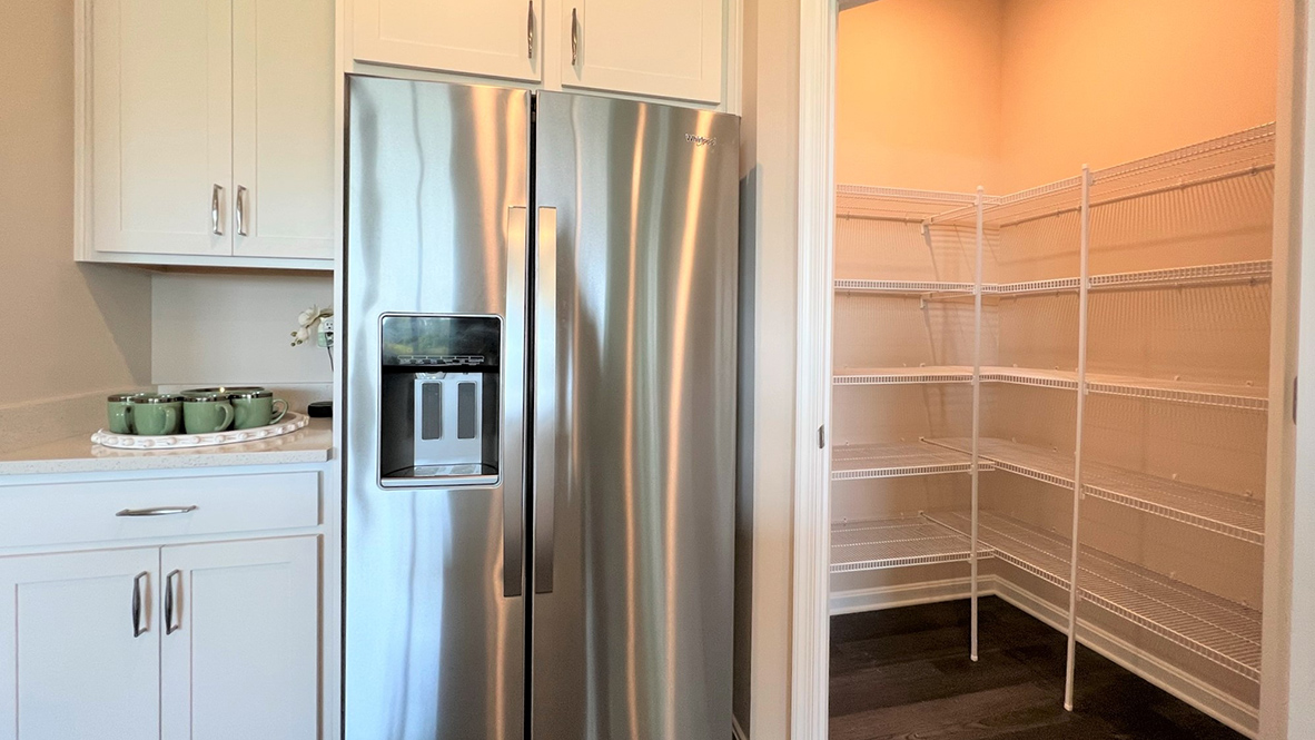In the corner of the kitchen is a walk-in pantry closet.
