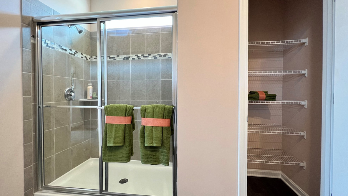 A linen closet is next to the shower.