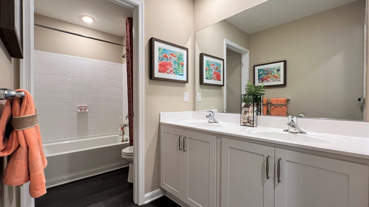 The bathroom has a double bowl vanity with tub shower.
