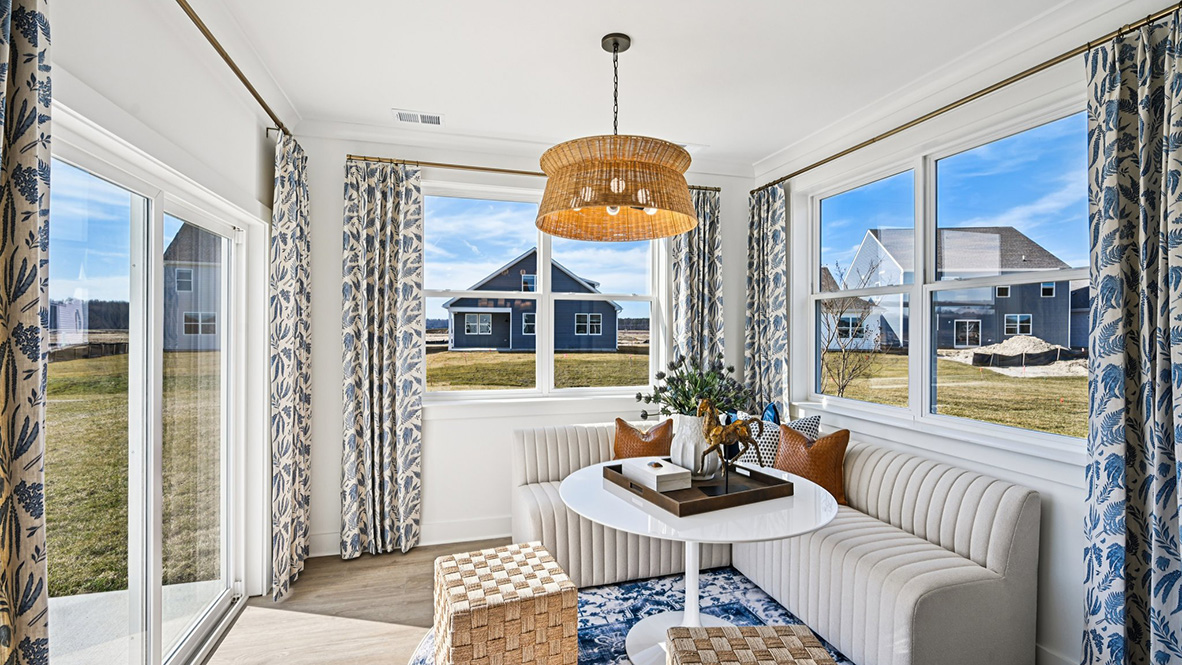 The sunroom is surrounded with windows and a sliding glass door.