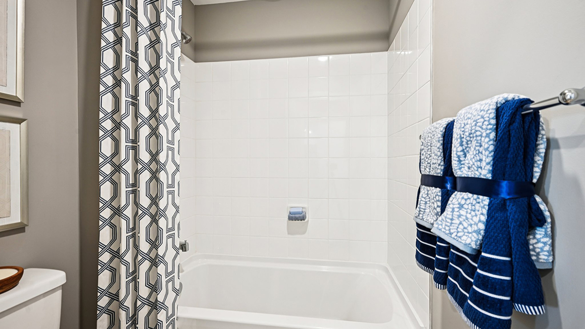 The bathroom has a tub shower.