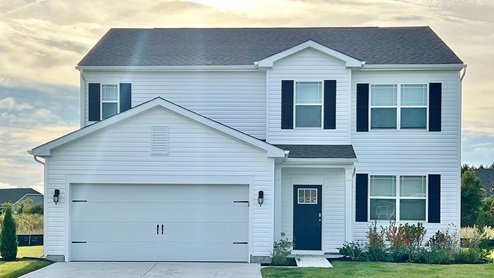 A Ellerbe home with white siding and black shutters.