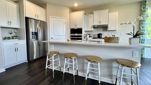 The large kitchen island has granite or quartz countertops.