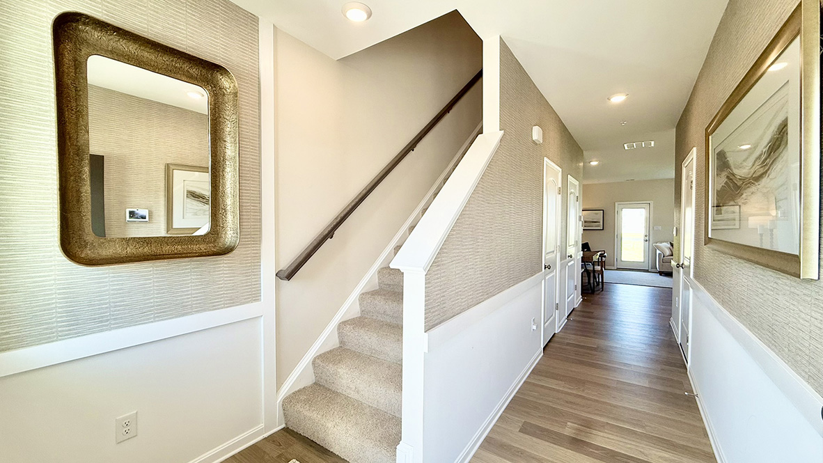 As you enter from the front porch, the inviting foyer leads you to a long hallway and stairwell.
