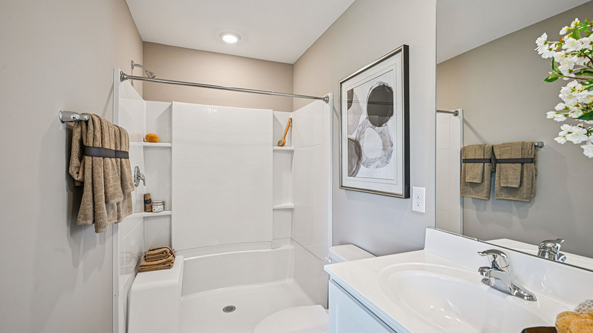 The modern main bathroom with a double bowl vanity, and generously sized walk-in shower.