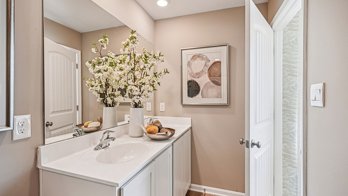 A guest bathroom with a vanity and tub shower is located down the hallway.