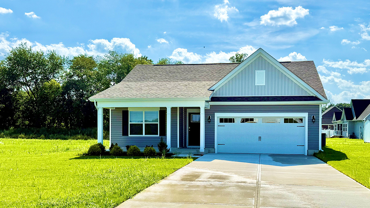 A Cali one-story home with tan siding and black shutters.