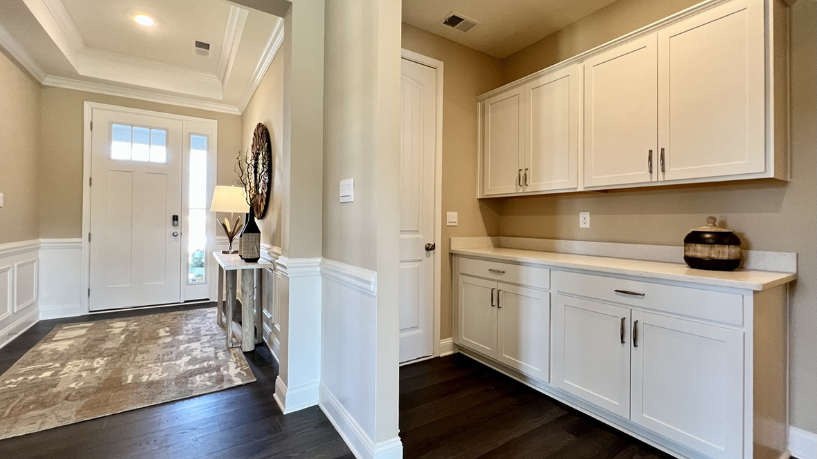 Extra storage cabinets are along the wall next to the three-car garage.