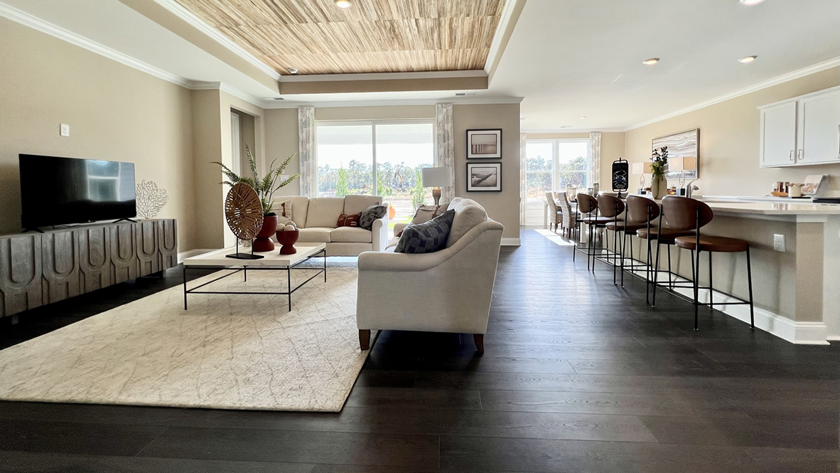 The open-concept great room with a tray ceiling leads you to the gourmet kitchen with an expansive island.